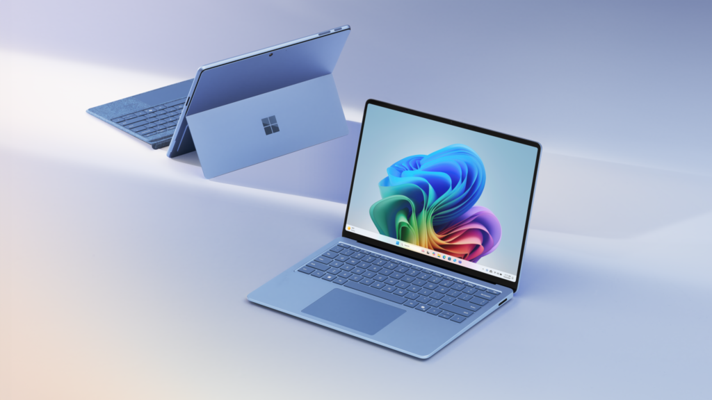 Two modern laptops with vibrant abstract wallpapers displayed on their screens, one facing forward and the other showing its back, both enhanced by Copilot+ PC technology, set against a gradient light background.