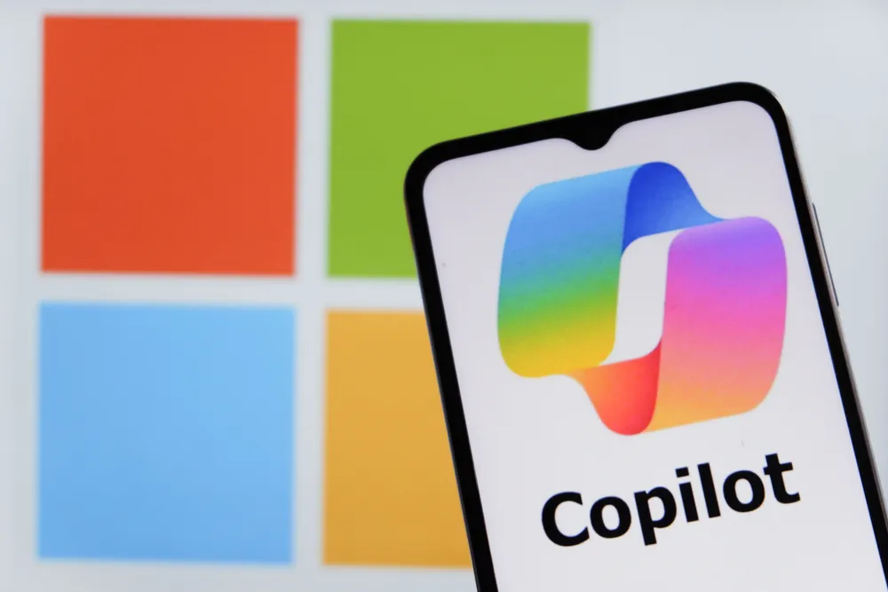 Smartphone screen showing the Microsoft Copilot logo in front of the Microsoft Windows colors, symbolizing an ai personal assistant for everyday work and life tasks