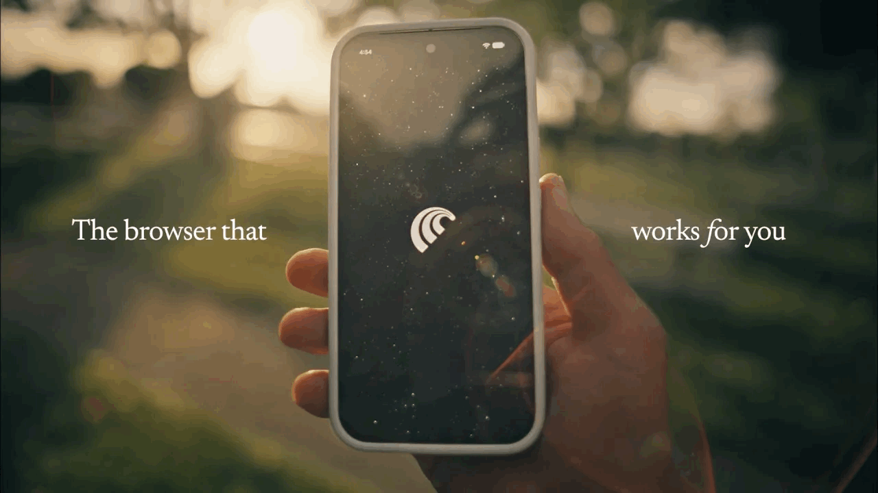 Person holding a smartphone outdoors displaying the Comet Assistant browser icon on screen