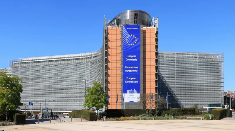 European Commission headquarters building with an EU banner, reflecting AI predictions about government rules and oversight.