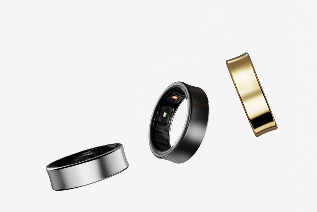 AI Wearables smart rings in silver, black, and gold finishes shown floating with visible internal sensors and health tracking components.