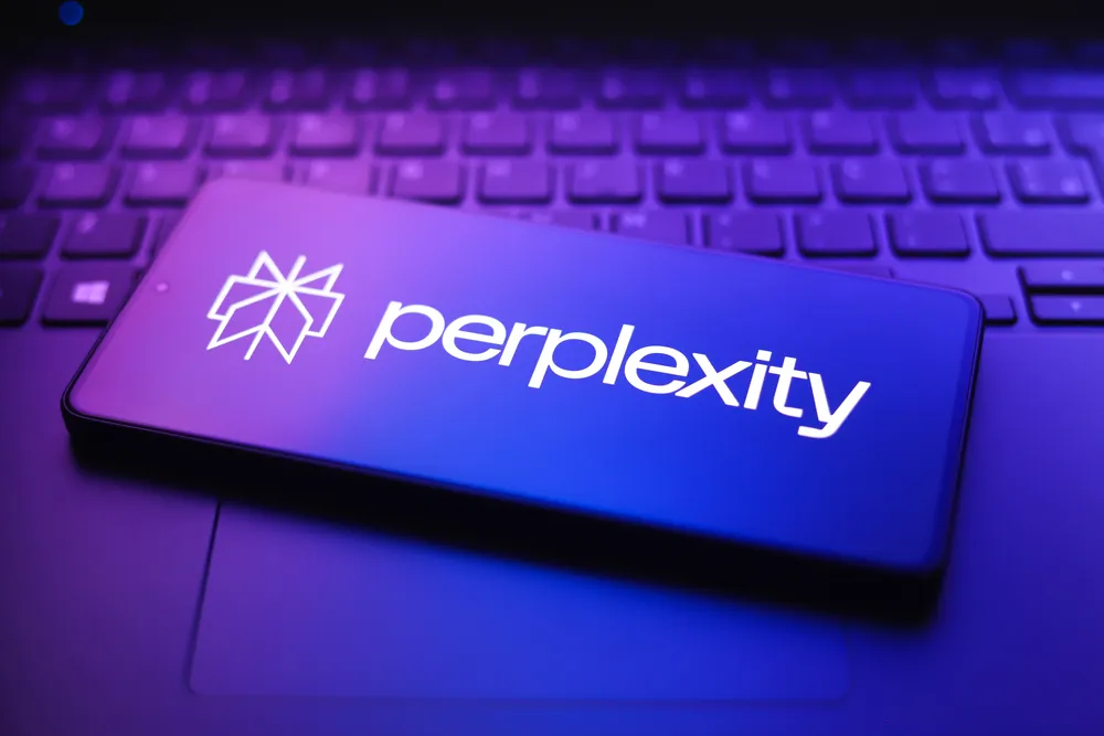 Perplexity Pro branded smartphone resting on a laptop keyboard with neon purple and blue lighting in a futuristic technology-themed close-up scene.